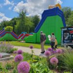 Galeria zdjęć z międzypokoleniowego pikniku rodzinnego „Miasto UśMiechów”, który odbył się 13 czerwca 2026 roku w Parku Miejskim w Miechowie. Fotografie przedstawiają uczestników wydarzenia korzystających z licznych atrakcji przygotowanych dla całych rodzin, w tym występów artystycznych, animacji, warsztatów, konkursów oraz stref aktywności. Na zdjęciach widoczni są mieszkańcy różnych pokoleń, psy biorące udział w konkursie „Najpiękniejszy pies i kot Gminy Miechów”, scena z prowadzeniem wydarzenia oraz ceremonia wręczania nagród. Piknik był okazją do wspólnej zabawy, integracji lokalnej społeczności i promowania aktywnego spędzania czasu w rodzinnej atmosferze.